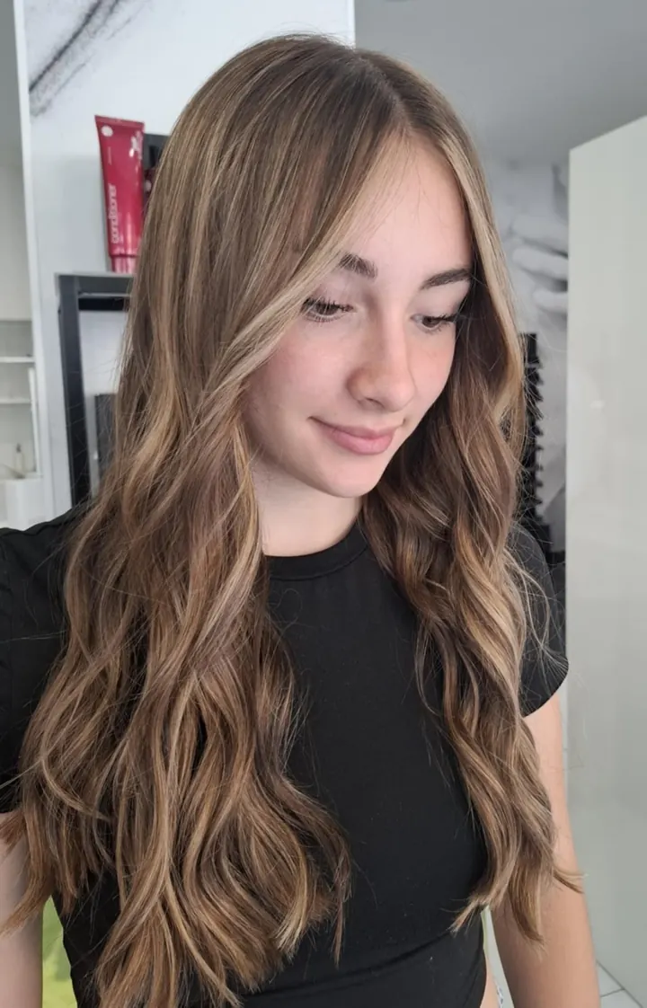 Ragazza con capelli lunghi mossi, castani con riflessi biondi