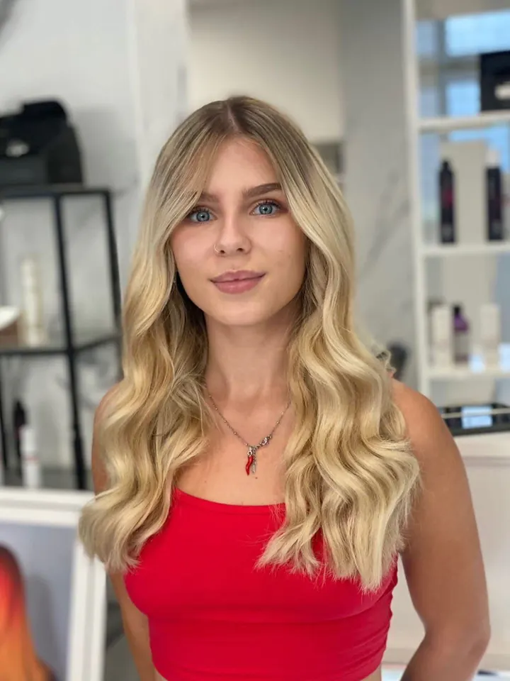 Cliente con i capelli lunghi biondi a onde morbide, vista di fronte