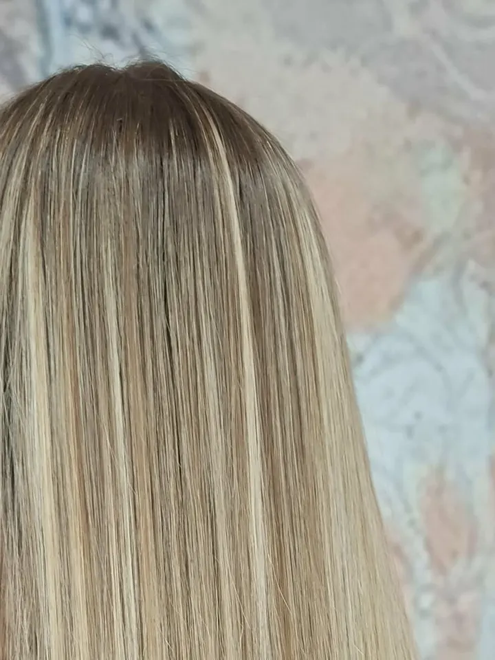 Capelli lunghi lisci biondi con ciocche più chiare, di spalle