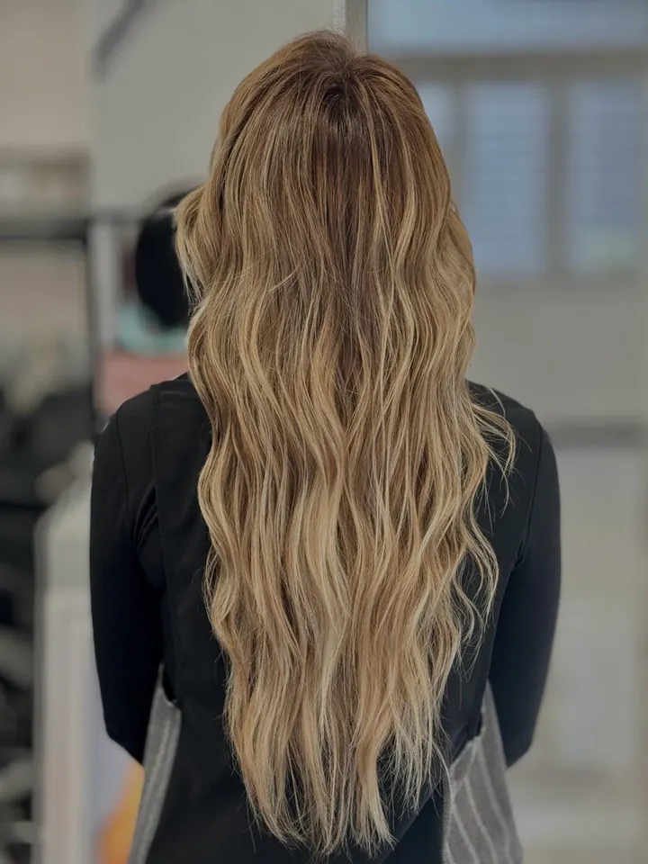 Capelli lunghissimi a onde, dal castano al biondo, di spalle