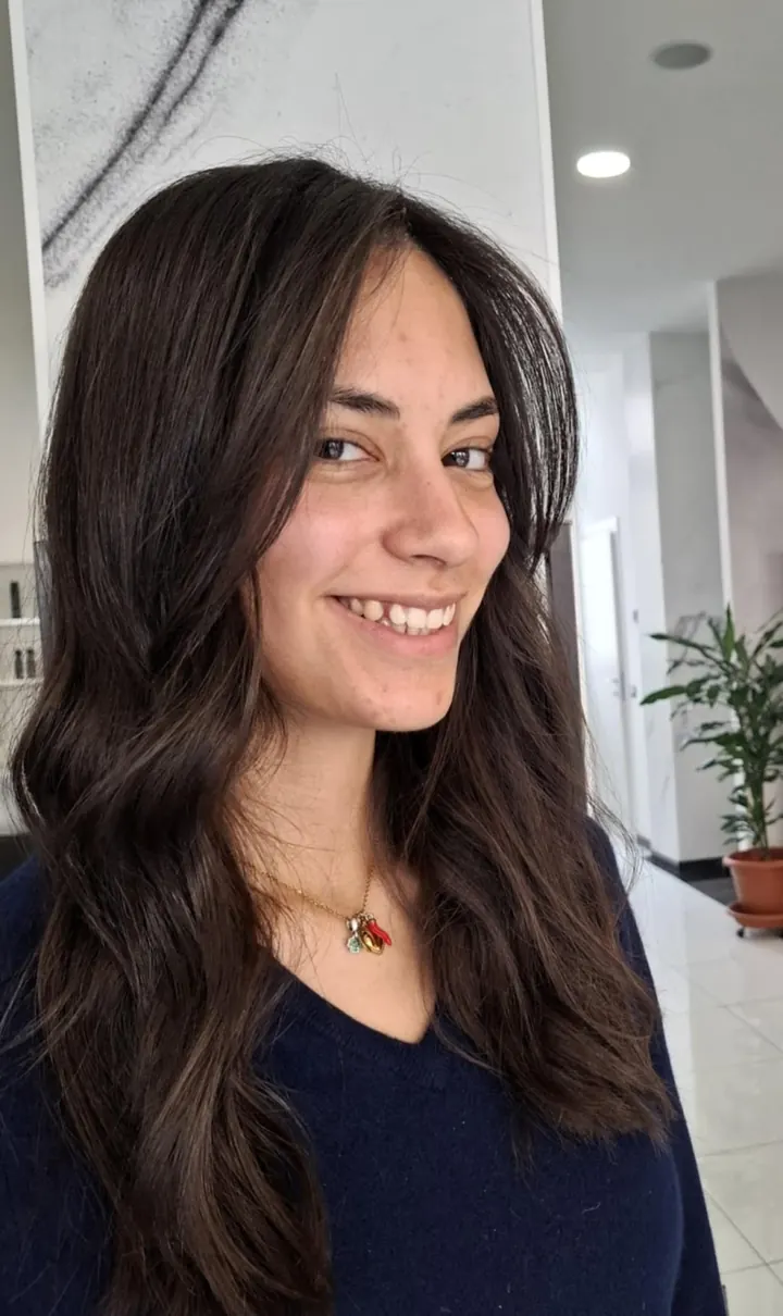 Ragazza con capelli lunghi castano scuro, mossi
