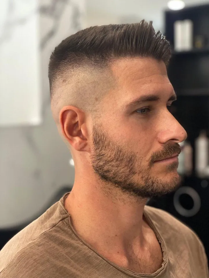 Uomo di profilo con la sfumatura e la barba curata