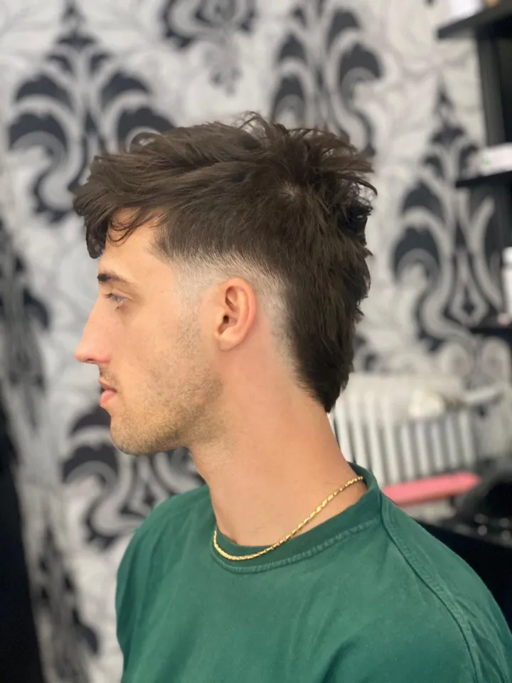 Ragazzo con il taglio mosso e la nuca sfumata, di profilo